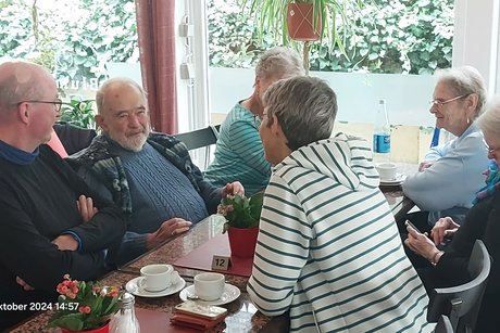 Mitglieder bei angeregter Unterhaltung bei Tisch
