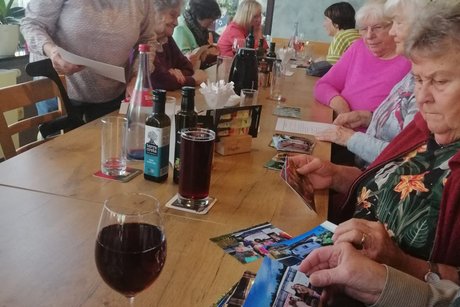 Einige weitere VdK'ler(innen), die sich die umhergereichten Bilder von der Reise im September anschauen Das Bild zeigt einige weitere VdK'ler(innen), die sich die umhergereichten Bilder von der Reise im September anschauen