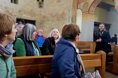 Alle sitzen in der Kirche mit den uralten Wandgem&auml;lden und h&ouml;ren unserer Reisebegleiterin zu.
