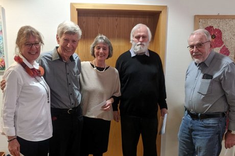 Zwei Damen und drei Herren posieren als Gruppenbild und l&auml;cheln in Richtung Kamera.