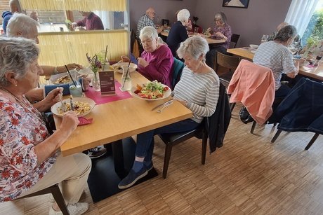 Personen sitzen am Tisch und essen