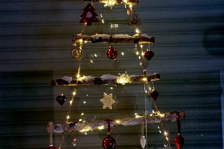 Fensterschmuck Weihnachtsbaum aus Birkenholz Fensterschmuck. Birkenholzstäbe verbunden mit Kordel in Form eines Tannebaumes mit Deko und Beleuchtung