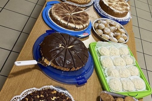 Auf dem Foto sieht man auf mehreren gro&szlig;en Tischen viele verschiedene Kuchensorten.