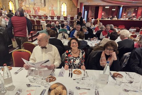 Gut gelaunte Besucherinnen und Besucher am gedeckten Tisch