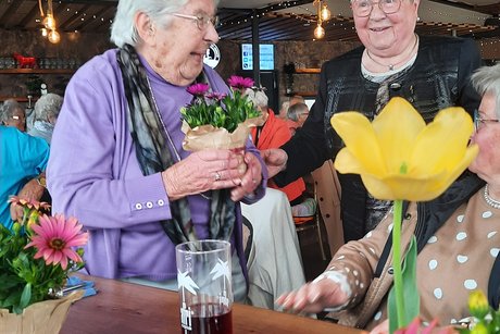Erika überreicht Marianne Blumen als ältestes Mitglied