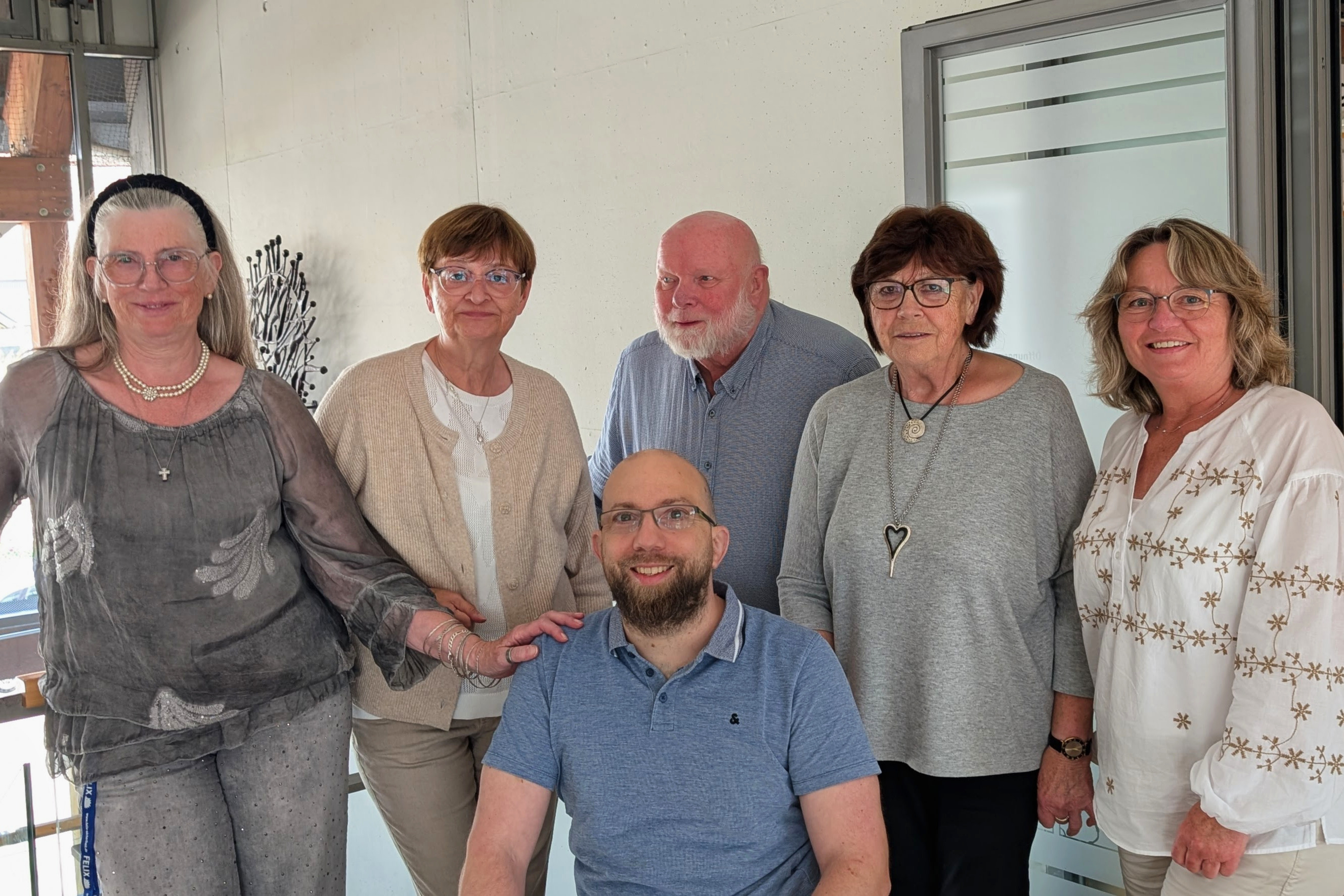 Gruppenbild mit vier &auml;lteren Damen, einem &auml;lteren Herrn und einem jungen Mann im Rollstuhl.