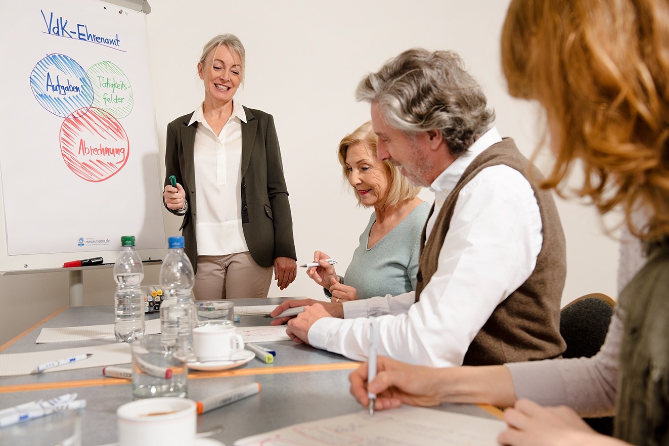 Teilnehmer eines Seminars sitzen an einem Tisch.