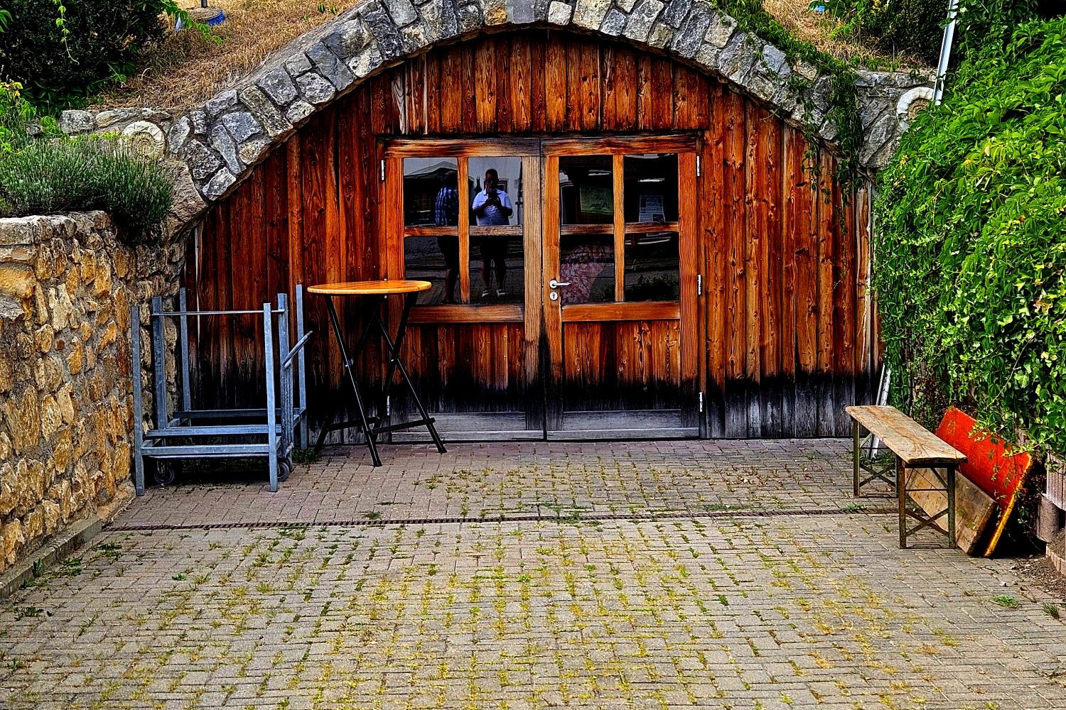 Der Gew&ouml;lbeeingang im Berg mit einer Holzfasade mit Fenster und T&uuml;r.
