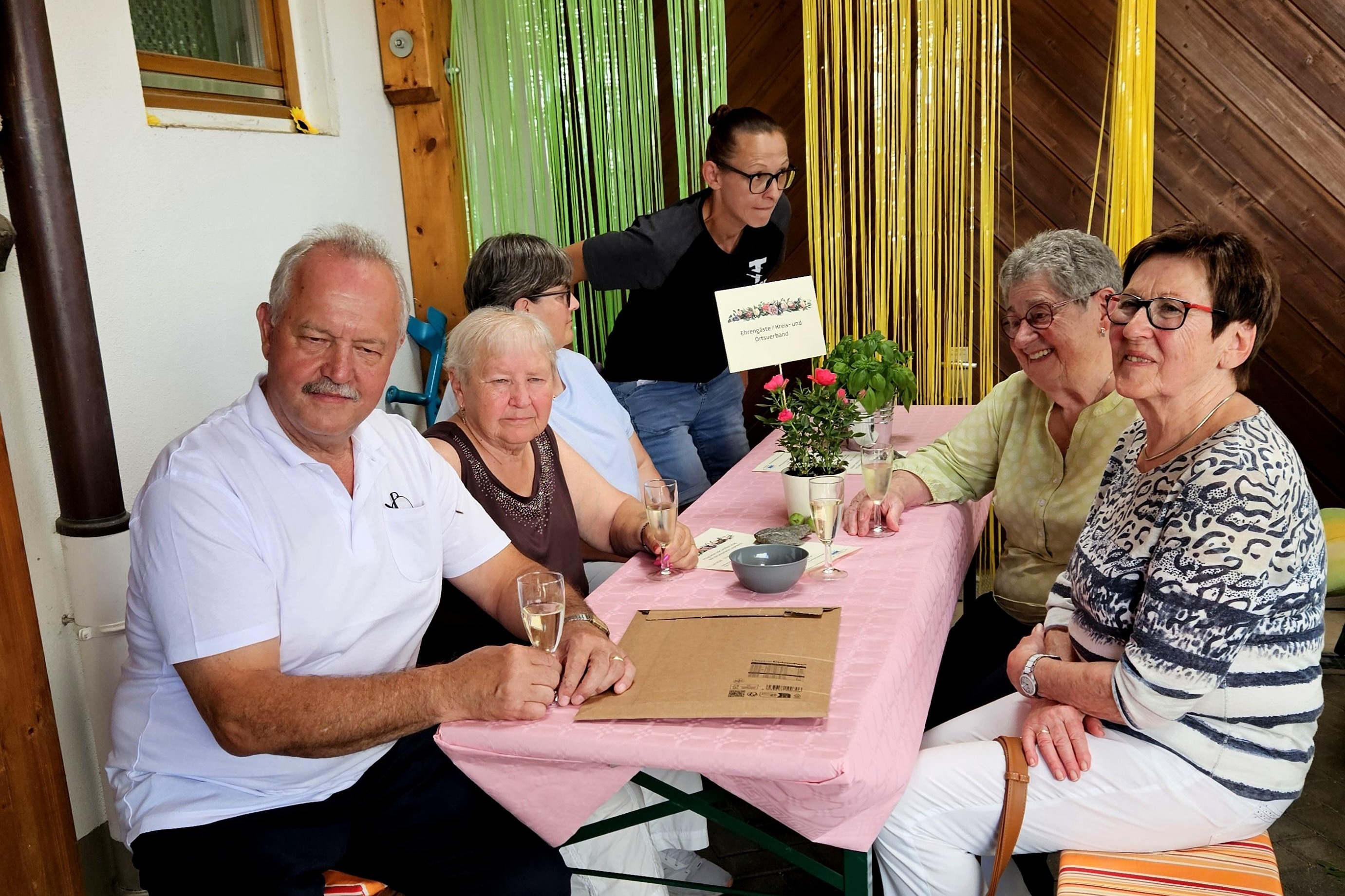 Ein besonders sch&ouml;n geschm&uuml;ckter Tisch im &uuml;berdachten Grillfestbereich besetzt mit Ehreng&auml;sten.