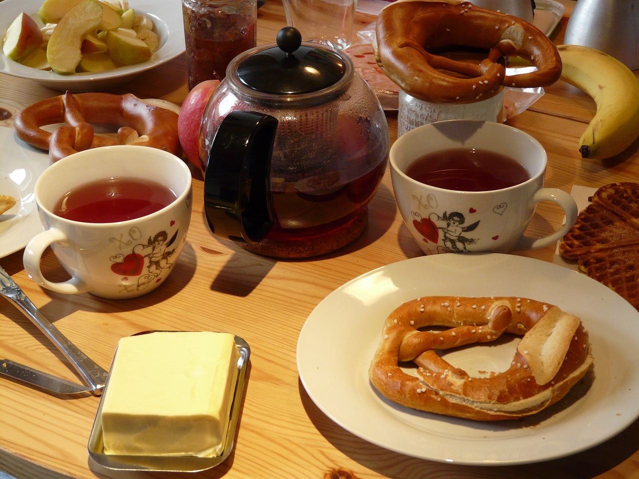 Frühstückstisch mit Tee und Brezeln und Butter