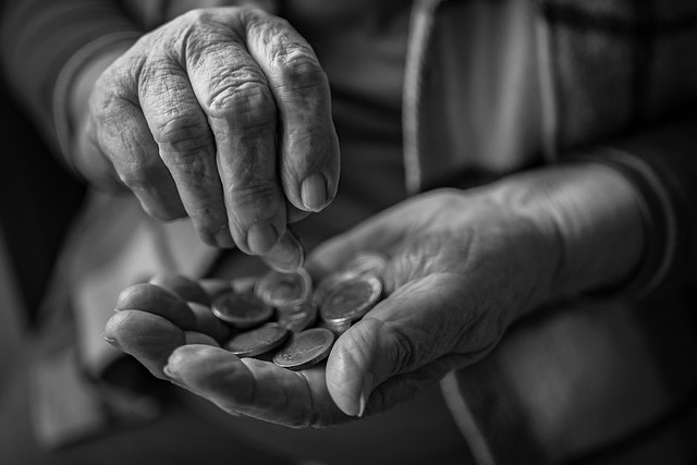 Auf dem Foto sieht man &auml;ltere H&auml;nde, die M&uuml;nzen z&auml;hlen