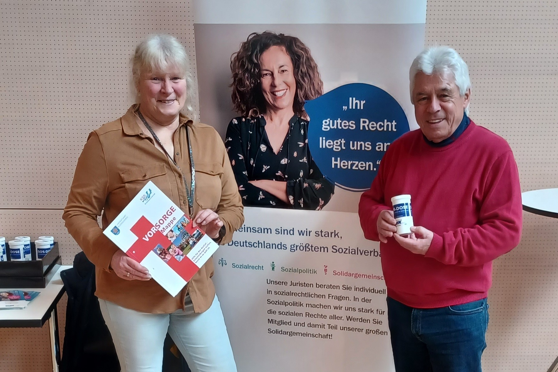 Zwei Mitglieder stehen vor dem VdK Aufsteller und werben f&uuml;r den VdK Kressbronn