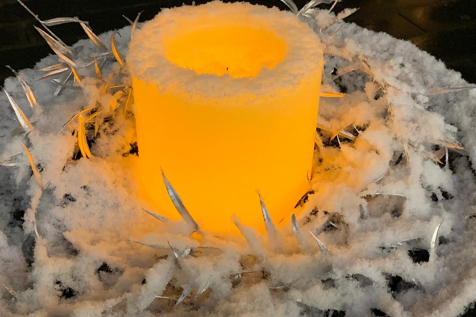 Kerze inmitten eines Schneekranzes