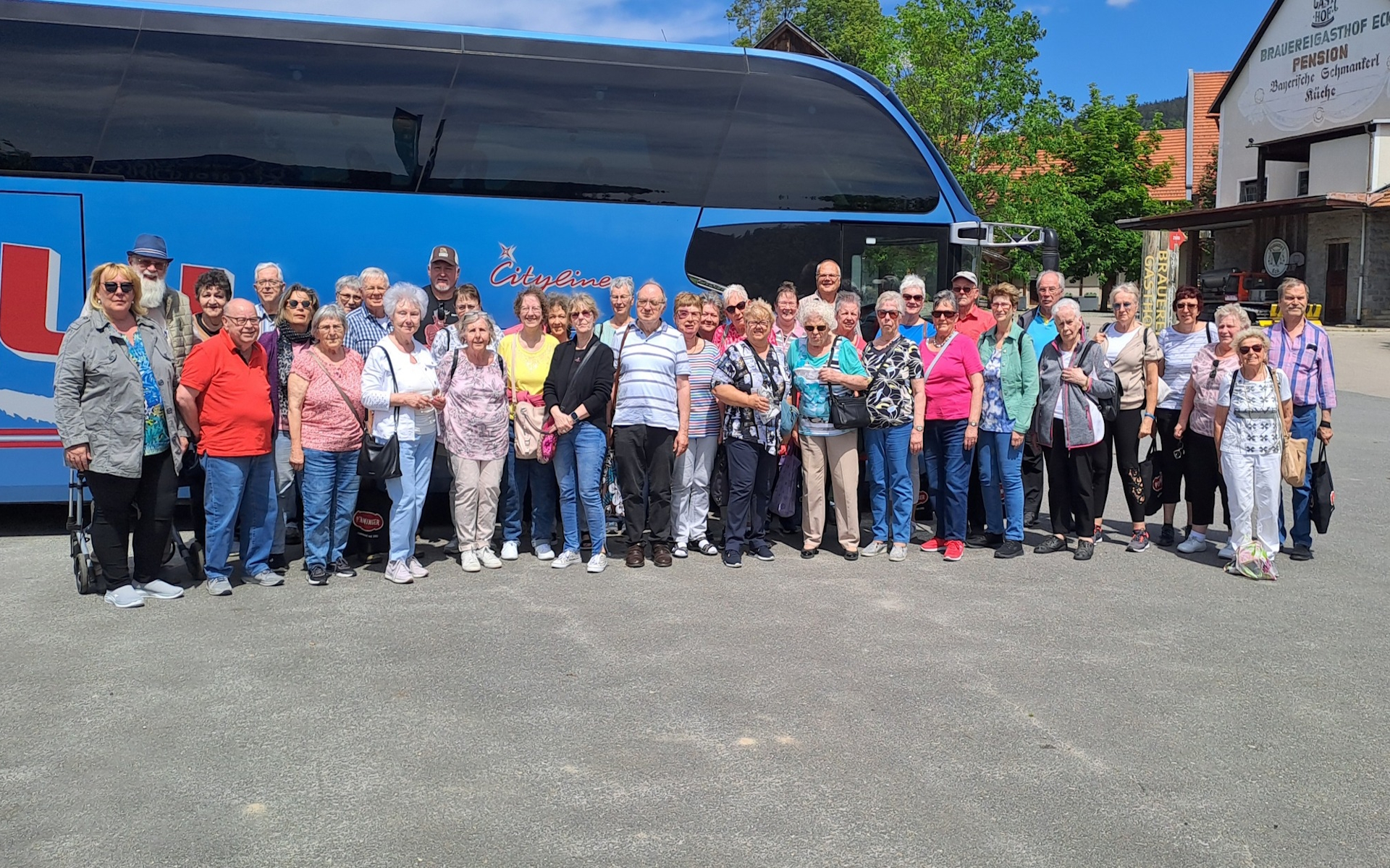 Bild zeigt die Reisegruppe vor dem Bus stehen