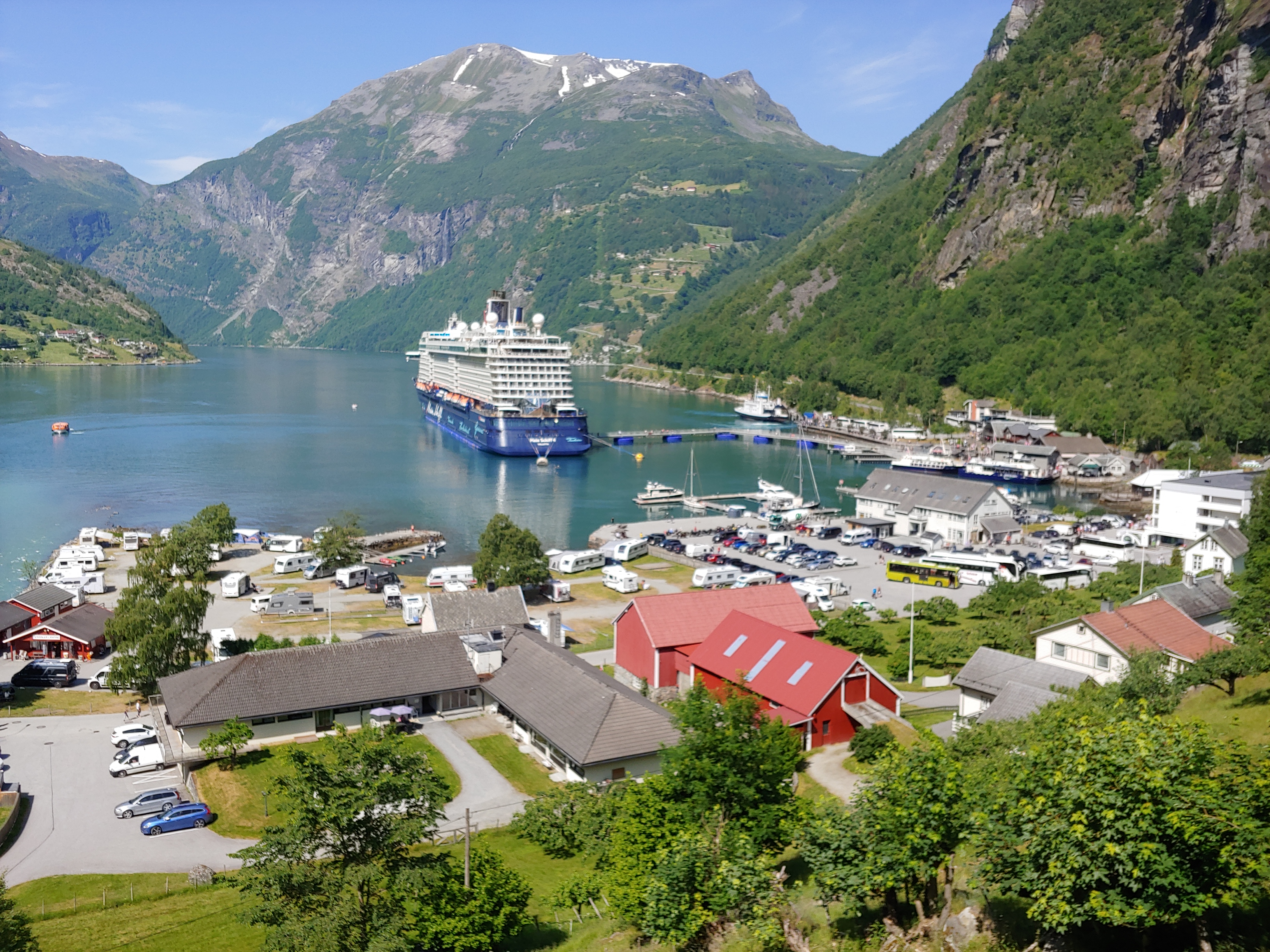 Fjord in Norwegen, mit Kreuzfahrtschiff und Häuser im Vordergrund