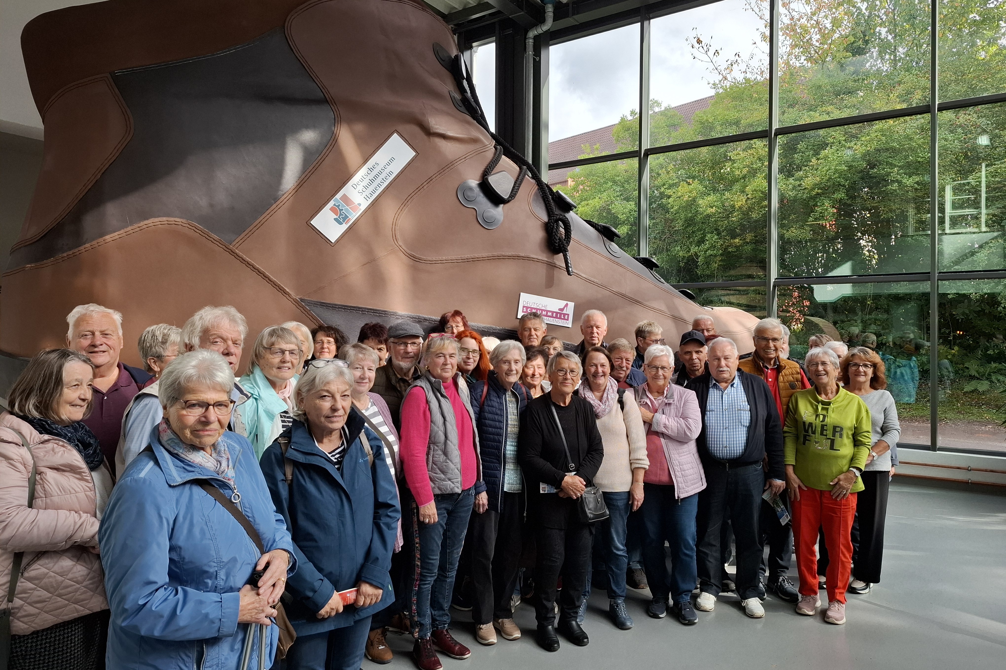 Gruppenbild vor dem gr&ouml;&szlig;ten Schuh der Welt im Deutschen Schuhmuseum in Hauenstein