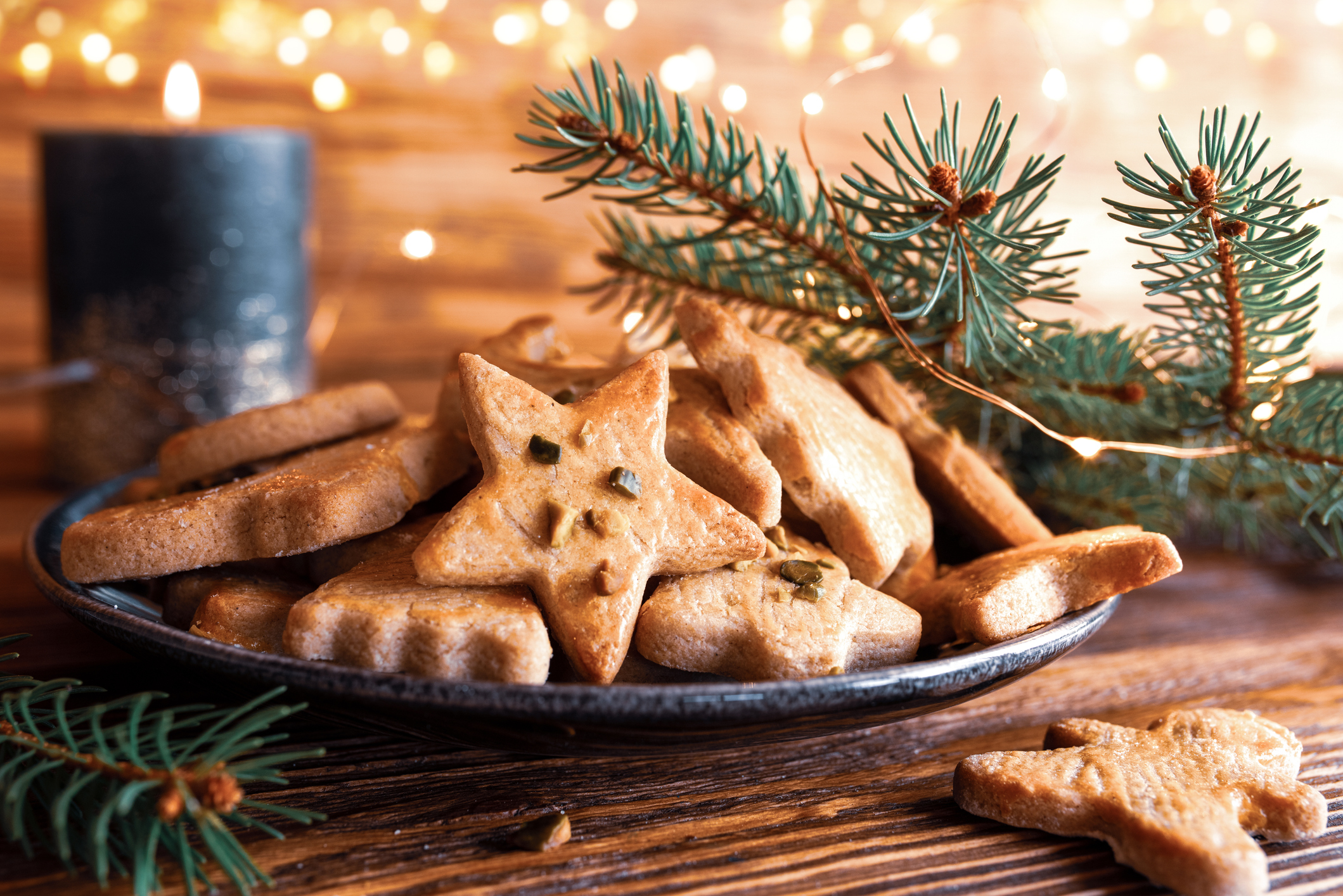 Teller mit Plätzchen, Kerze und Tannenzweig