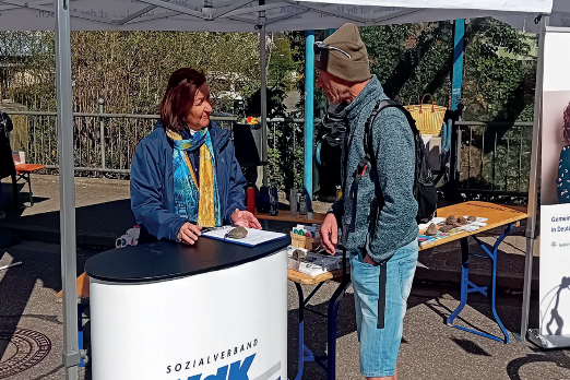 Die Ortsvorsitzende Brigitte Mauz und ein Besucher im Gespr&auml;ch am VdK-Infostand