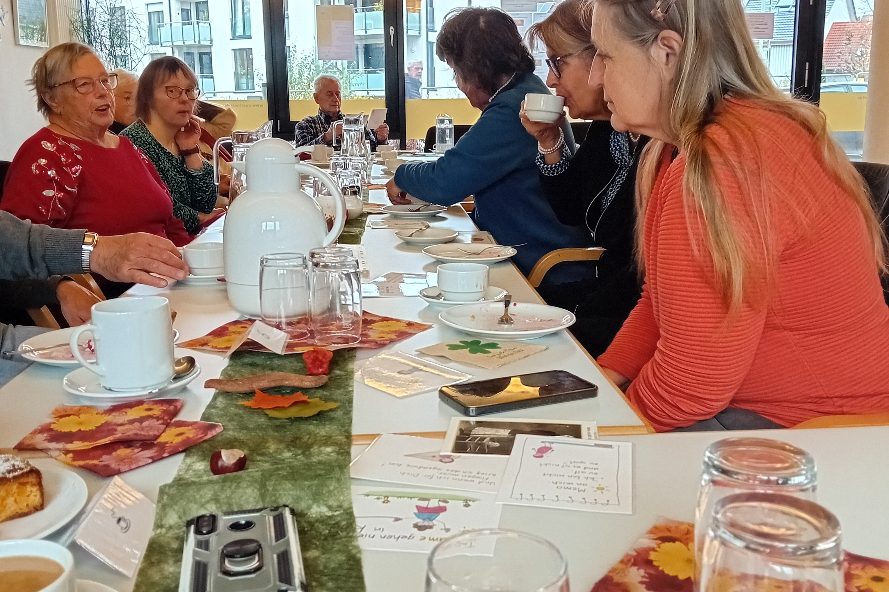 An der Kaffeetafel sitzend Besuchende beim Caf&eacute; f&uuml;r ALLE/Caf&eacute; Tr&ouml;stlich