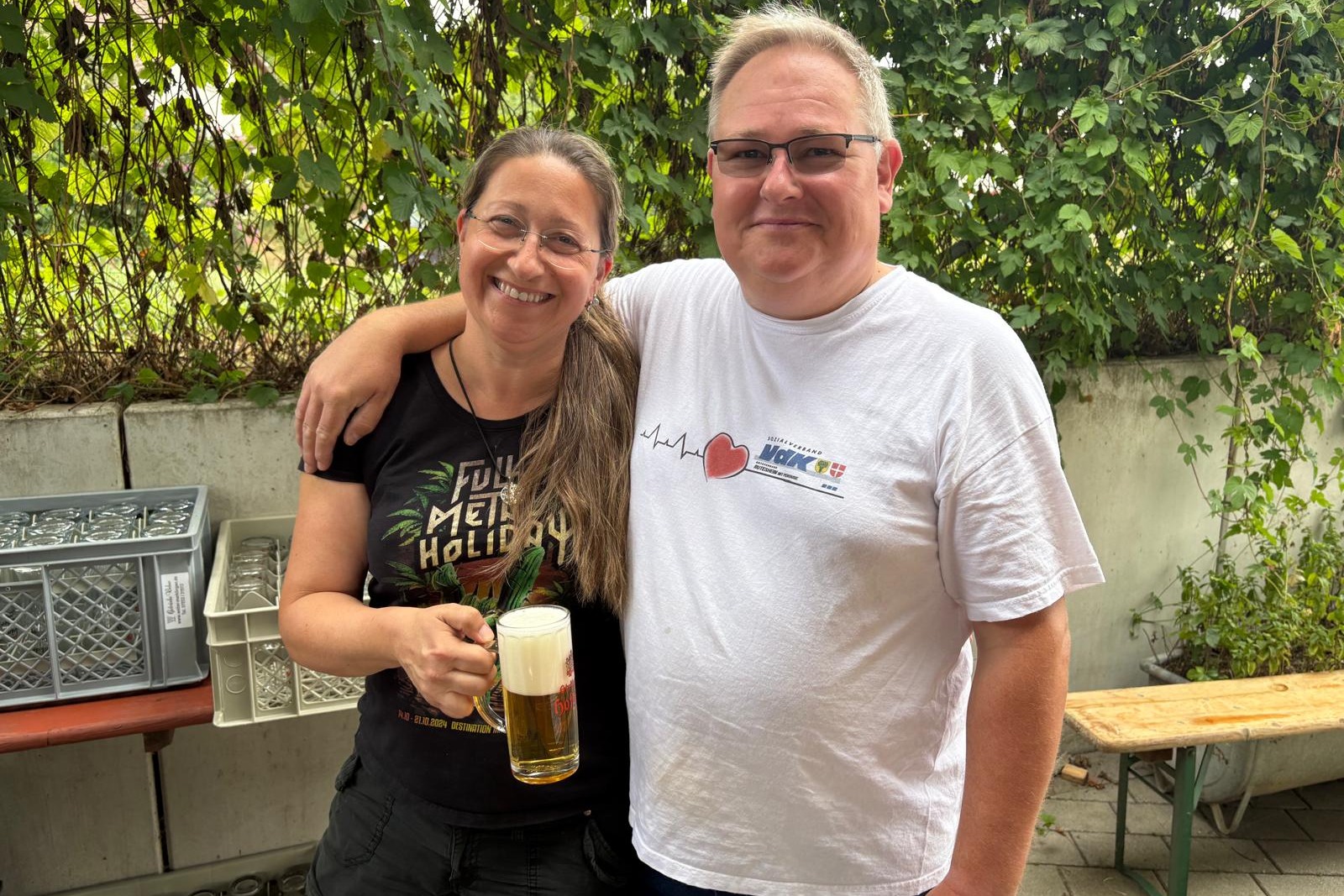 Das Photo zeigt Martina Oberrauch und Arndt Minter lachend Arm in Arm mit einem frisch gezapften Bier in der Hand.