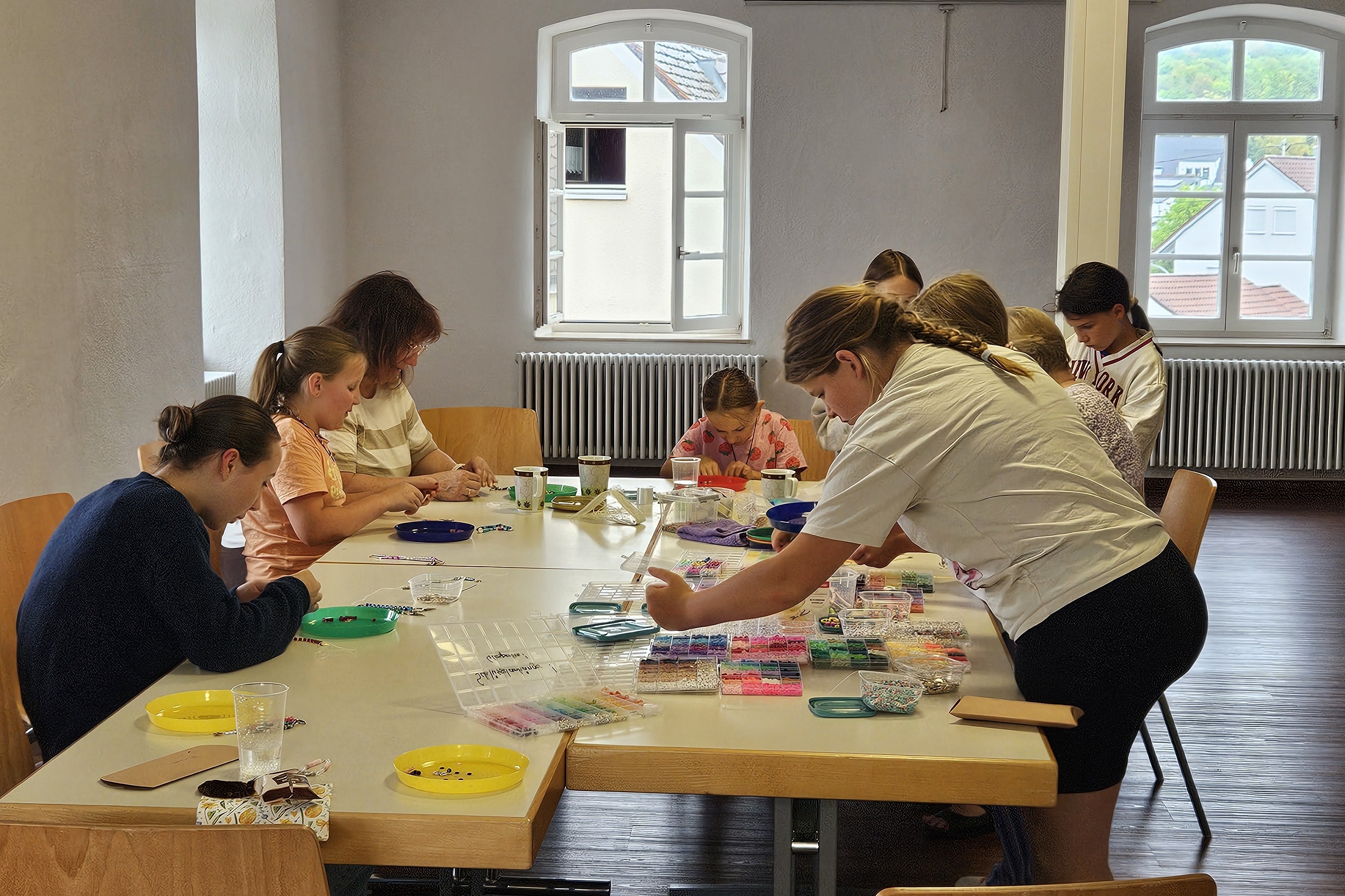 mehrere Personen um einen Tisch gruppiert, konzentriert bei der Arbeit