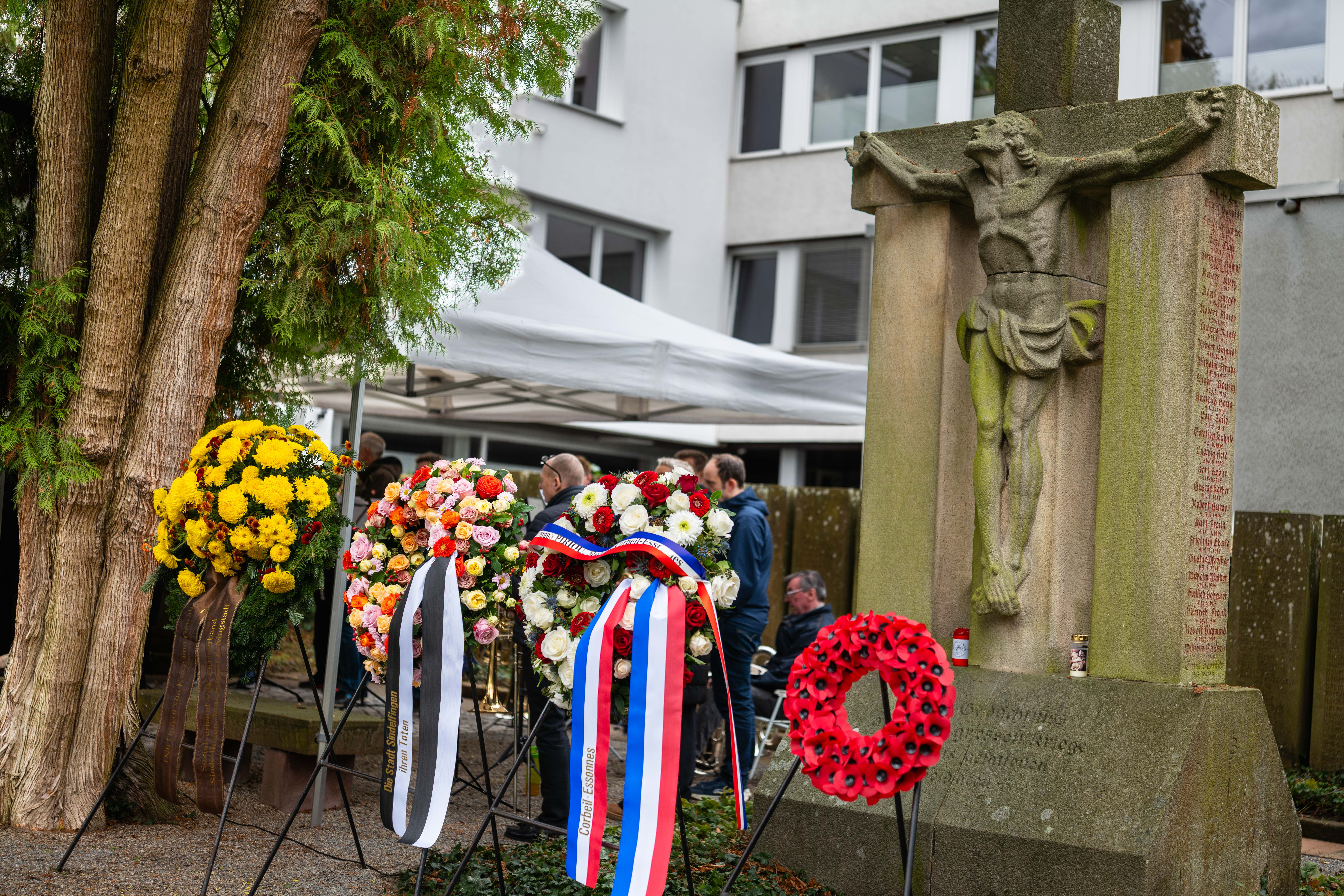 Auf dem Foto von der Veranstaltung sind die Kränze und das Denkmal auf dem alten Friedhof in Sindelfingen zu sehen.