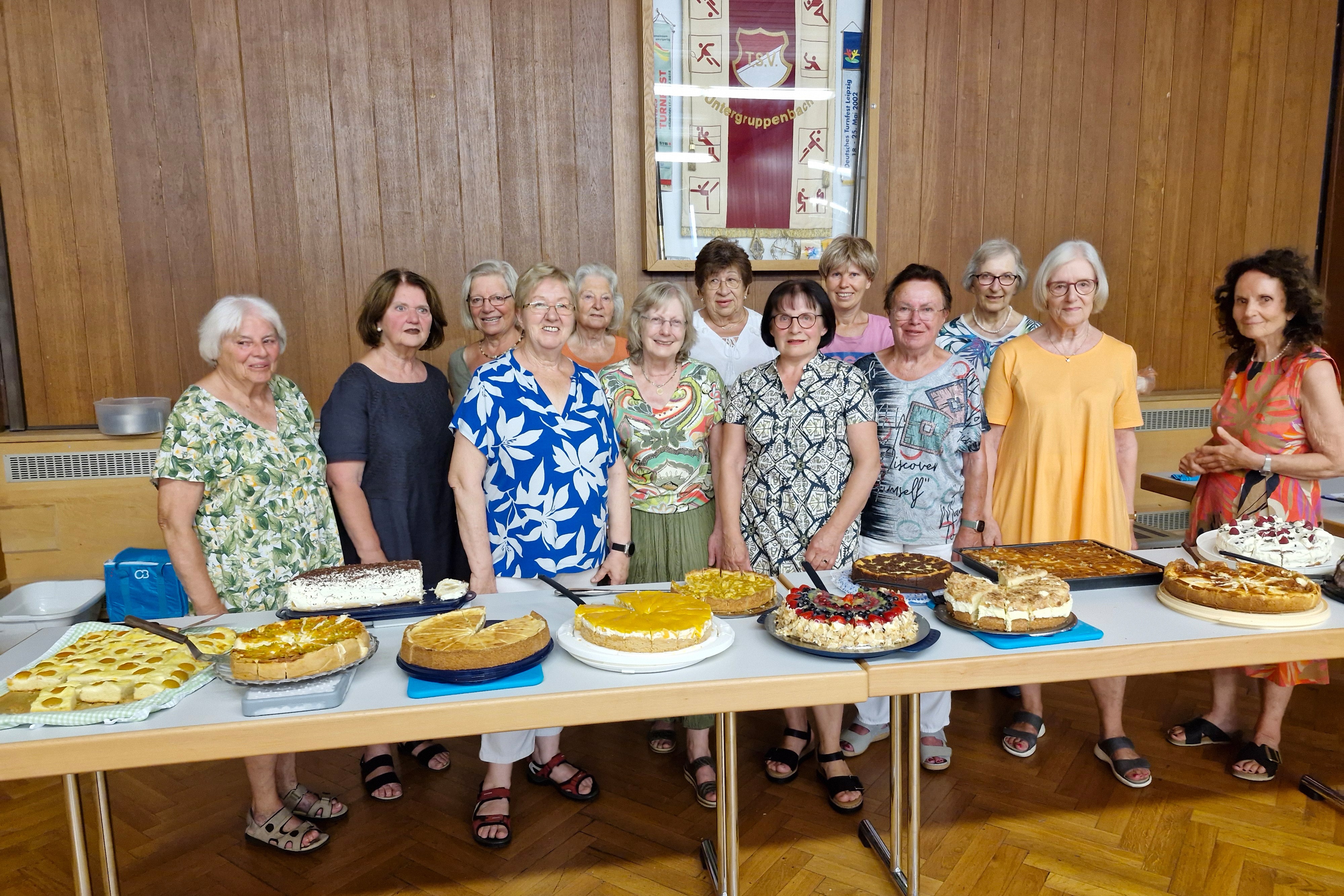 Leckere Kuchen mit Spenderinnen Vordergrund Tische mit 12 verschiedenen selbstgebackenen Kuchen, dahinter die Kuchenspenderinnen