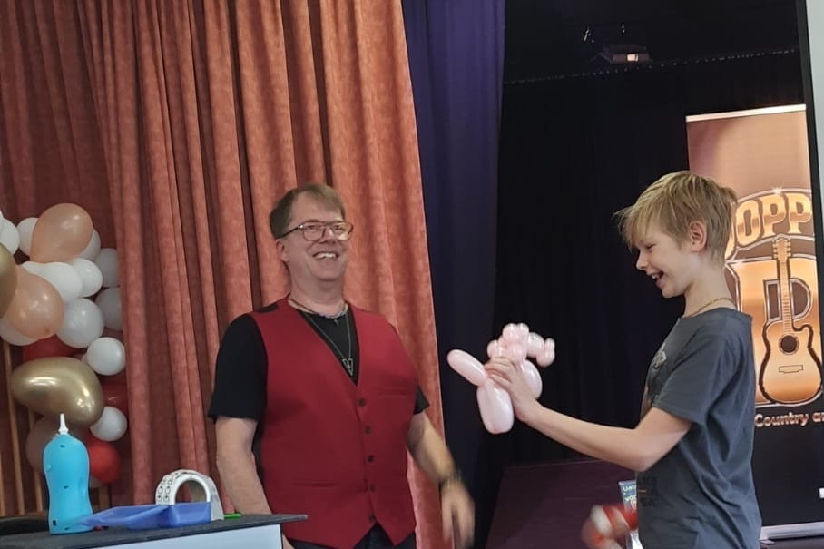 Der Zauberer Olli G zaubert einem Jungen eine Ballonfigur
