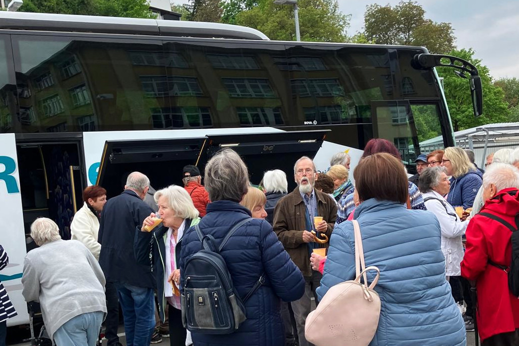 Busausflug Menschengruppe vor einem Reisebus.