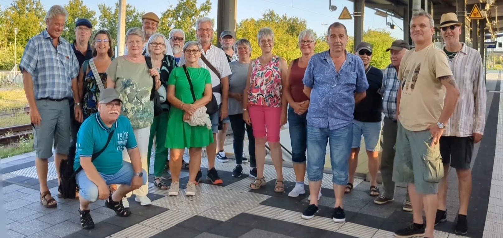 Gruppe von Männern und Frauen am Bahnhof